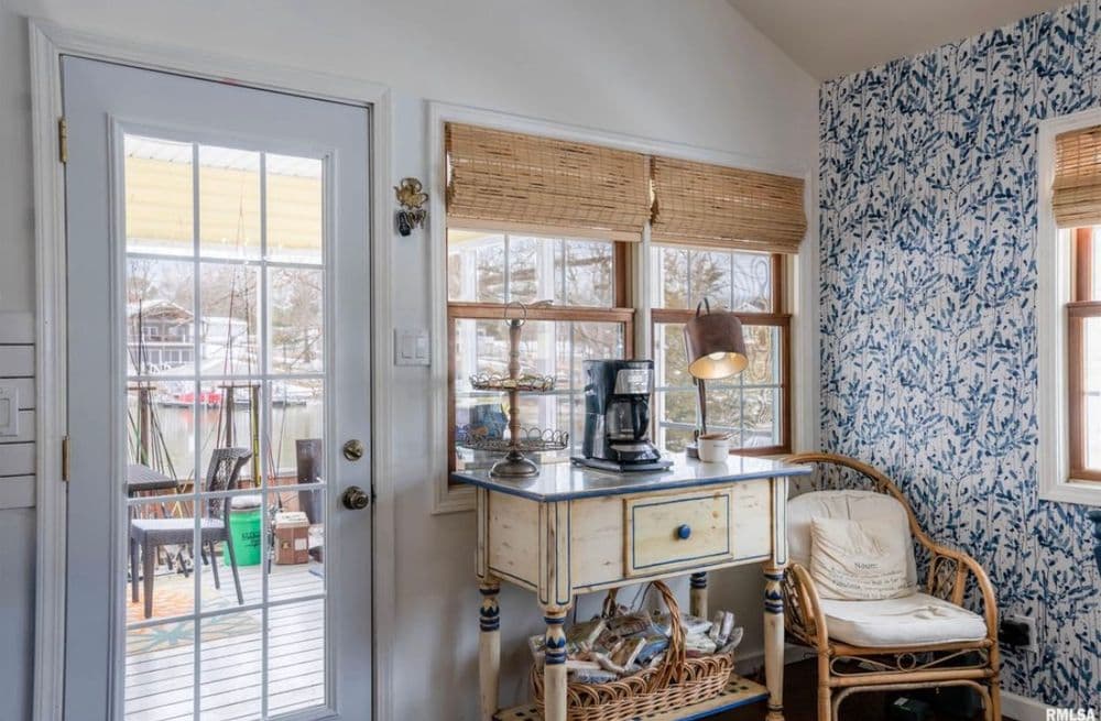Cozy bright kitchen corner with floral wallpaper, coffee station, and rustic decor.