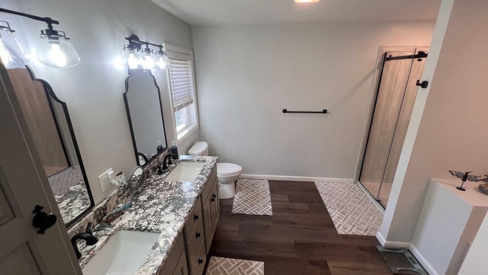 Modern bathroom with gray walls, undermount sink, marble countertop, and walk-in shower.