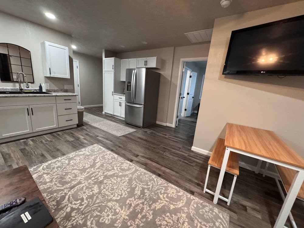 Modern kitchen and dining area in a renovated apartment with sleek appliances and wooden accents.