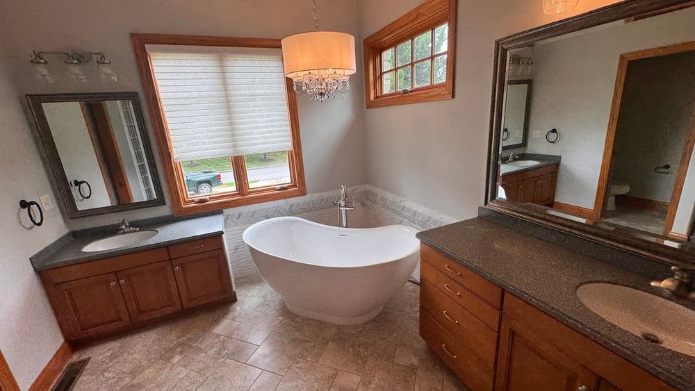 Modern bathroom featuring a freestanding tub, double vanity sinks, and stylish decor.